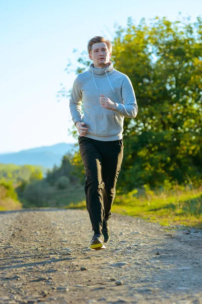 Man jogging in rural nature at beautiful summer day. Sport fitness model caucasian ethnicity training outdoor. — Stock Photo, Image