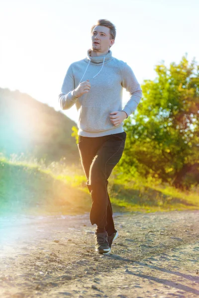 Man jogging in rural nature at beautiful summer day. Sport fitness model caucasian ethnicity training outdoor. — Stock Photo, Image