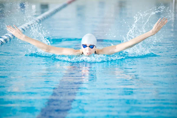 Mädchen schwimmt im Schmetterlingsschlagstil — Stockfoto