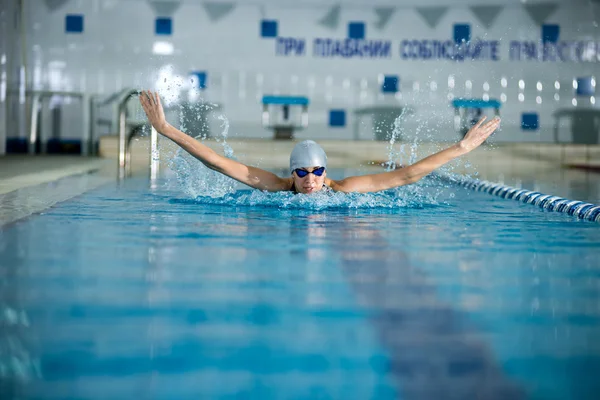 Девушка, плавающая в стиле бабочки — стоковое фото