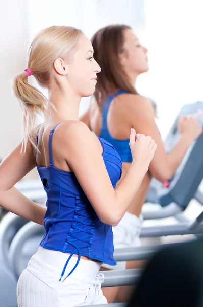 Women run on machine in gym — Stock Photo, Image