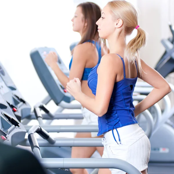 Women run on machine in gym — Stock Photo, Image