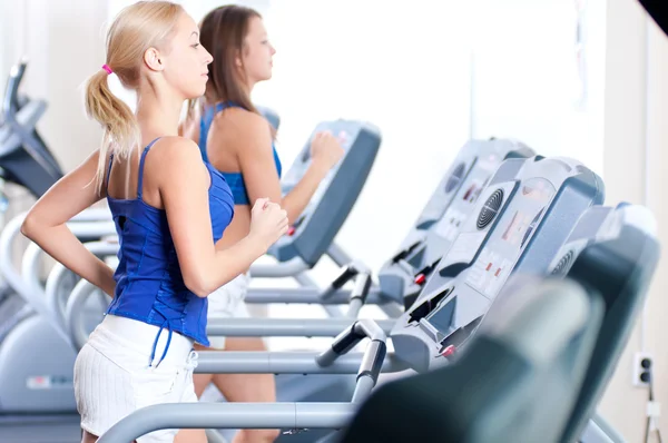 Les femmes courent sur la machine dans le gymnase — Photo