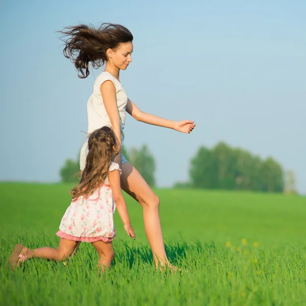 Meninas correndo no campo de trigo verde — Fotografia de Stock