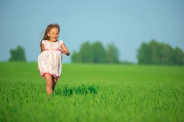 Chica corriendo en el campo de trigo verde — Foto de Stock