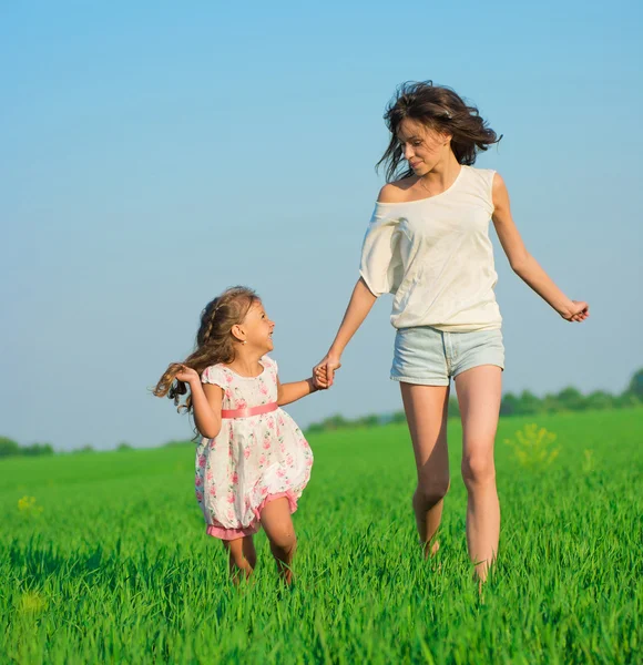 Дівчата біжать на полі зеленої пшениці — стокове фото