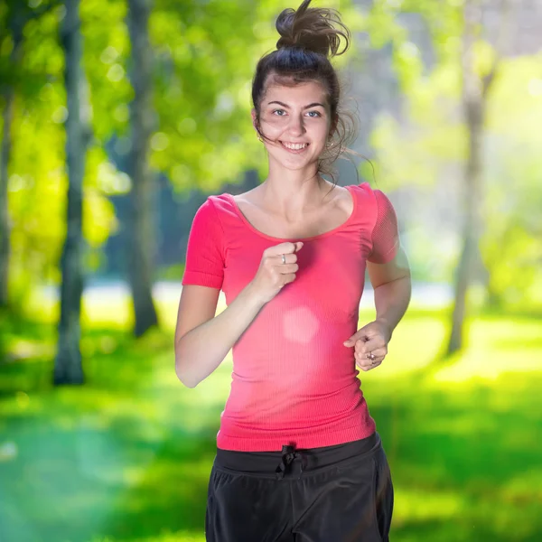 Frau läuft im grünen Park ins Freie — Stockfoto
