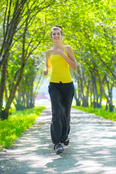 Frau läuft im grünen Park ins Freie — Stockfoto
