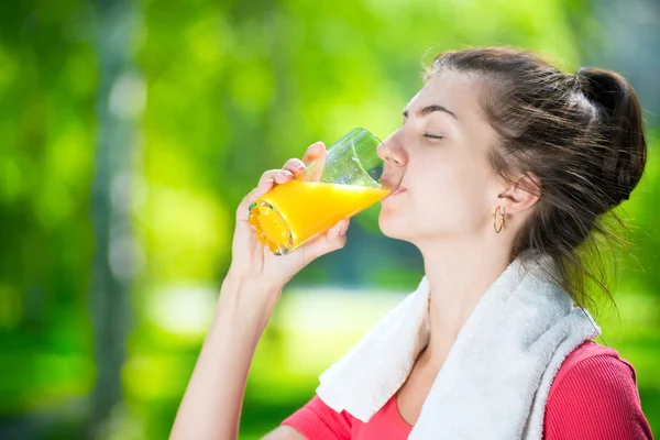 Kvinna dricka färskpressad apelsinjuice — Stockfoto