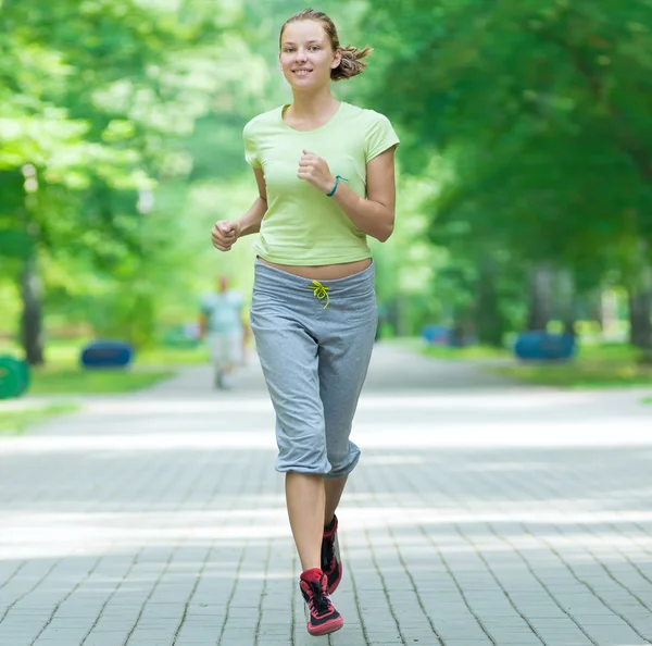 Frau joggt im Stadtpark. — Stockfoto