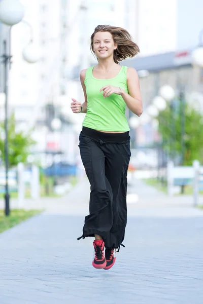 Žena běhání v ulici městský park. — Stock fotografie
