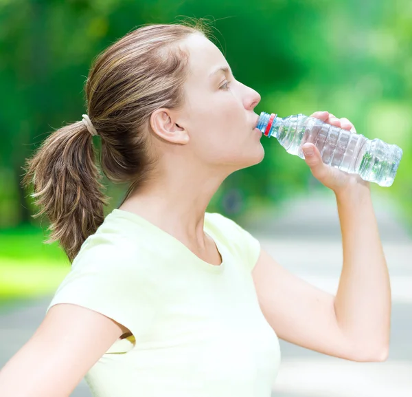 Mujer bebiendo agua de una botella — Foto de Stock