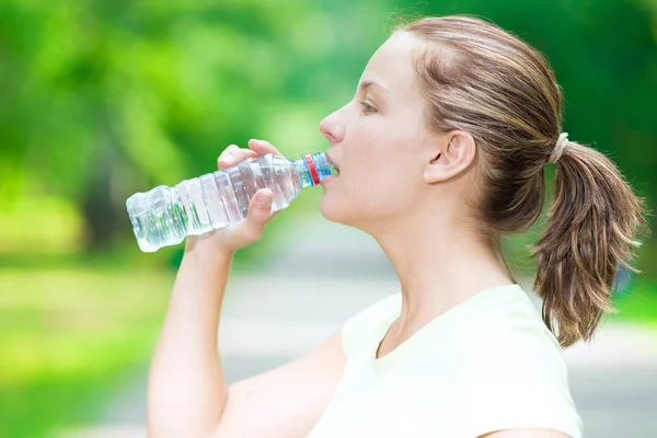 Woman drinking water from a bottle — Stock Photo, Image