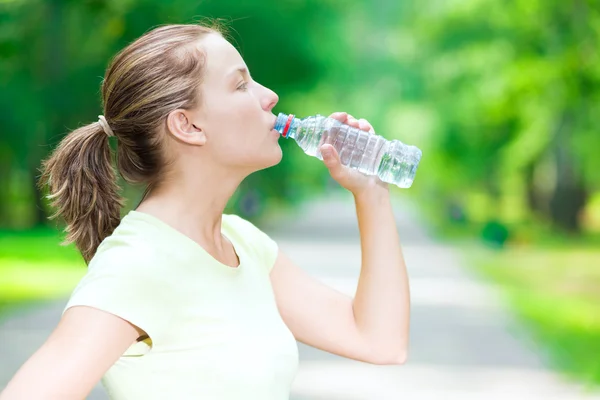 Woman drinking water from a bottle — Stock Photo, Image