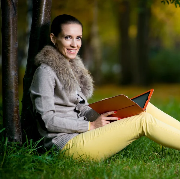 Γυναίκα, χρησιμοποιώντας έναν υπολογιστή δισκίο, στο πάρκο — Φωτογραφία Αρχείου