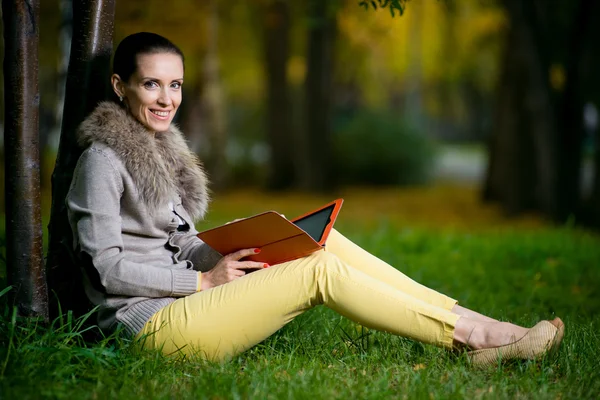 Kobieta przy użyciu komputera typu tablet w parku — Zdjęcie stockowe