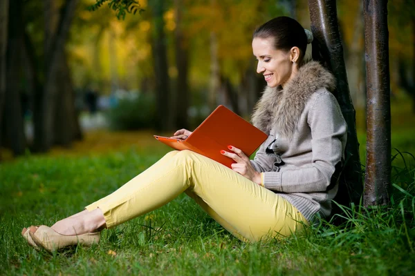 Vrouw met behulp van een tablet-pc in park — Stockfoto