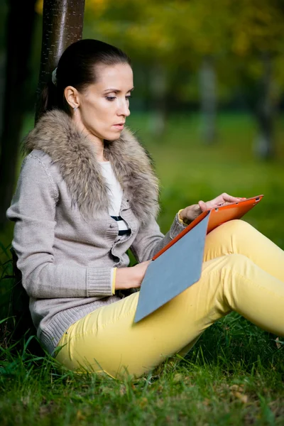 Vrouw met behulp van een tablet-pc in park — Stockfoto
