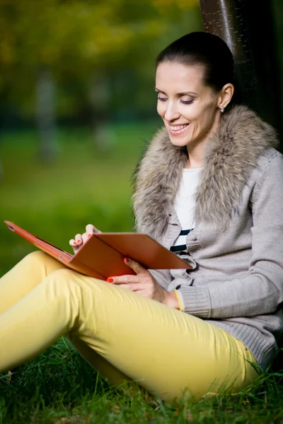 Vrouw met behulp van een tablet-pc in park — Stockfoto