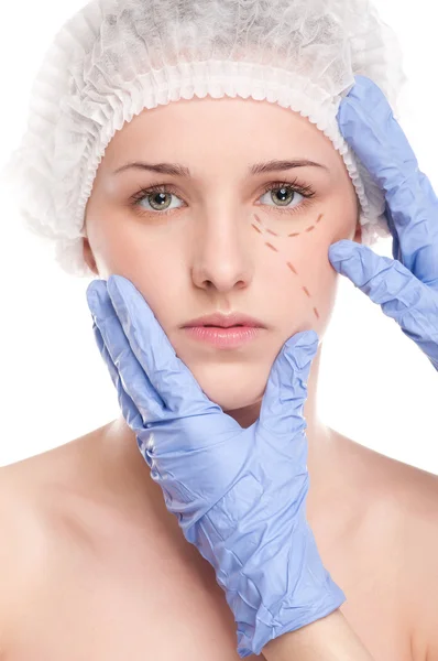Kosmetikerin zieht Korrekturlinien auf Frauengesicht — Stockfoto