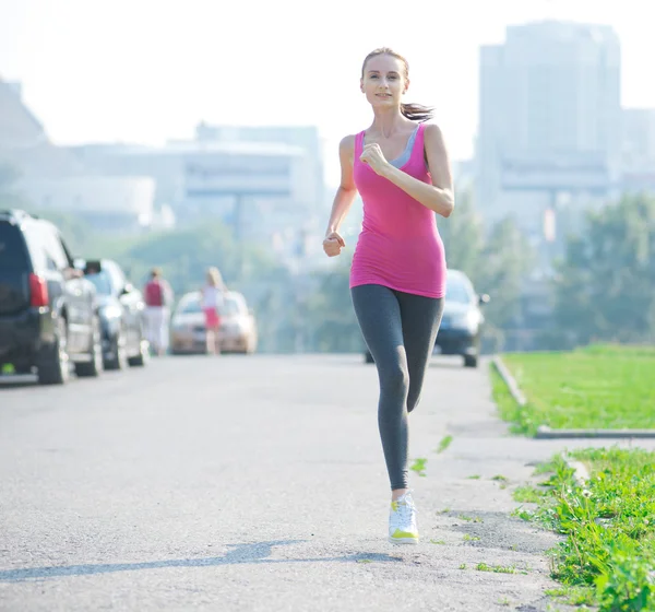 Woman running in city park — Stock Photo, Image