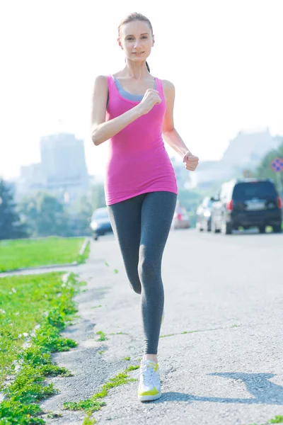 Woman running in city park — Stock Photo, Image