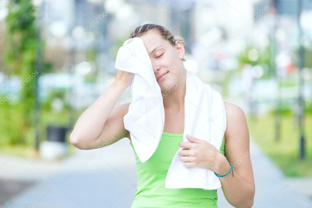 Tired woman after fitness time in city park