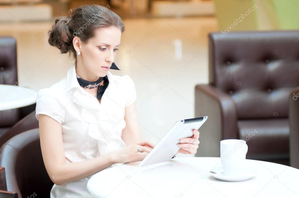 Businesswoman using tablet on in cafe