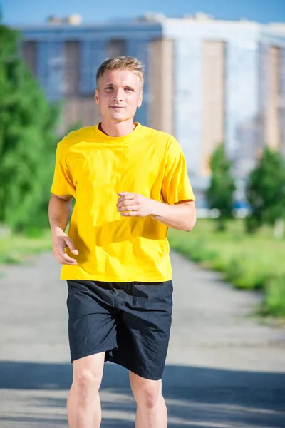 Sporty man jogging in city street park. Outdoor fitness. — Stock Photo, Image