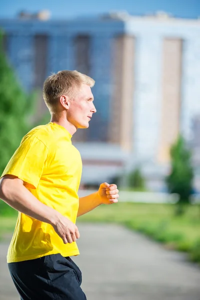 Sportieve man joggen in straat skyline van de stad. Buiten fitness. — Stockfoto