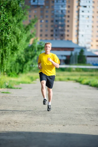 Sportieve man joggen in straat skyline van de stad. Buiten fitness. — Stockfoto