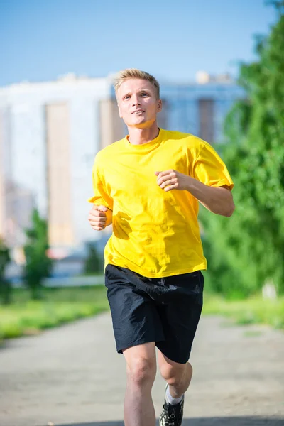 Sportieve man joggen in straat skyline van de stad. Buiten fitness. — Stockfoto