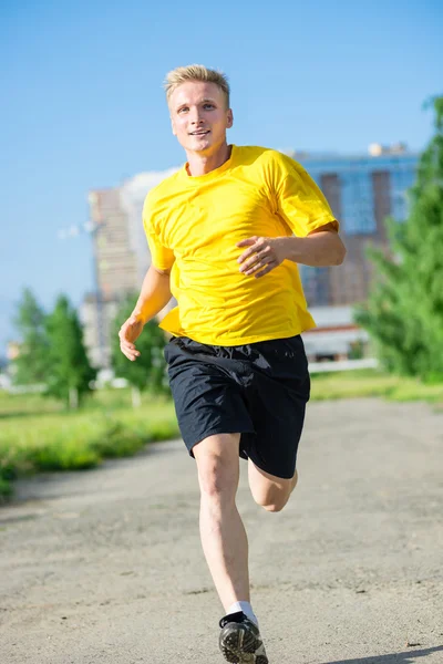 Sporty man jogging in city street park. Outdoor fitness. — Stock Photo, Image