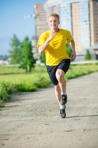 Sporty man jogging in city street park. Outdoor fitness. — Stock Photo, Image