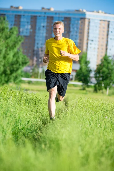 Sportieve man joggen in straat skyline van de stad. Buiten fitness. — Stockfoto