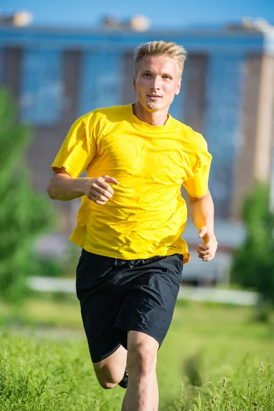 Sportlicher Mann joggt im Stadtpark. Fitness im Freien. — Stockfoto