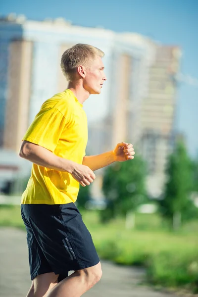 Sportieve man joggen in stad straat park. — Stockfoto