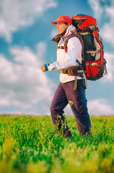 Wanderer mit Rucksack im Feld unterwegs — Stockfoto