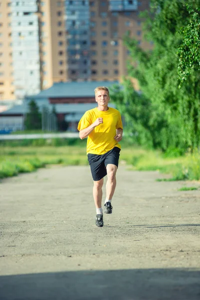 Sportieve man joggen in stad straat park — Stockfoto