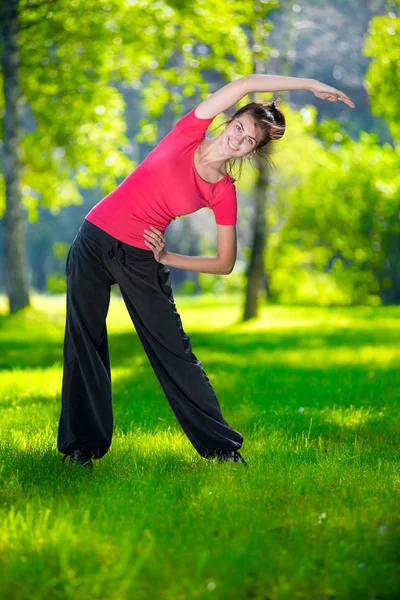 Vrouw die zich uitstrekt in outdoor sport oefening. — Stockfoto