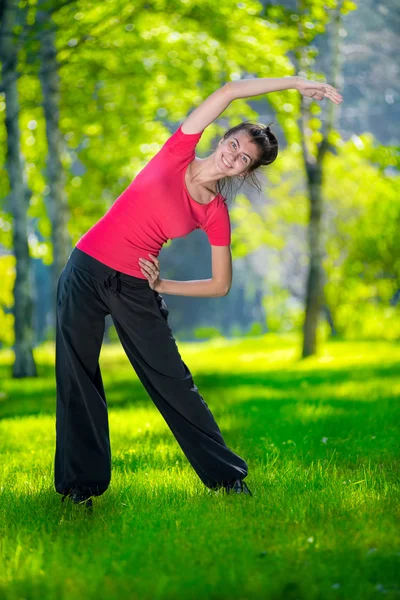 Розтяжка жінка в спортивних вправах на відкритому повітрі . — стокове фото