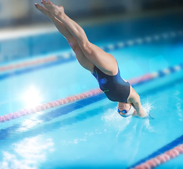 Female swimmer jumping into swimming pool. — Stock Photo, Image