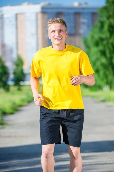 Sportieve man joggen in stad straat park. — Stockfoto