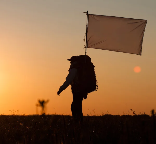 Hiker with backpack and flag — Stock Photo, Image