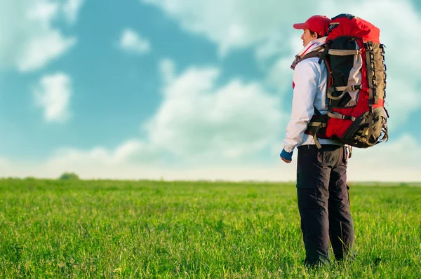 Wandelaar met rugzak staan in het veld — Stockfoto