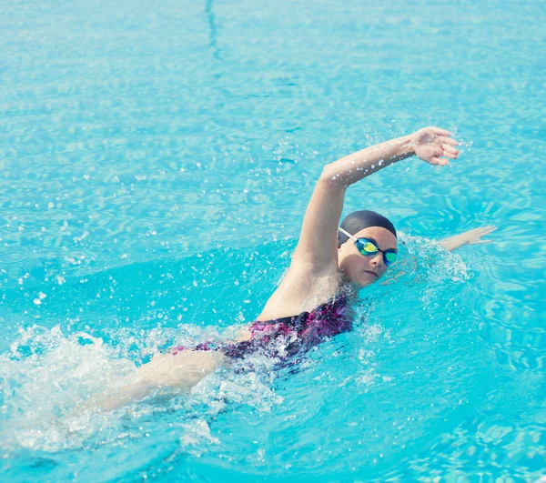 Woman in goggles swimming front crawl style — Stock Photo, Image