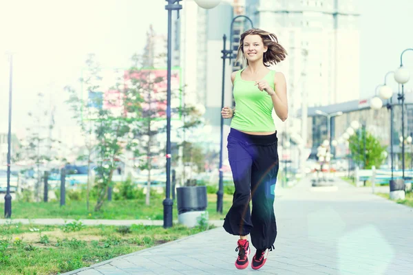 Kvinna jogging i gatan stadsparken. — Stockfoto