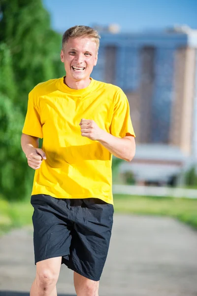 Sporty man jogging in city street park. Outdoor fitness. — Stock Photo, Image