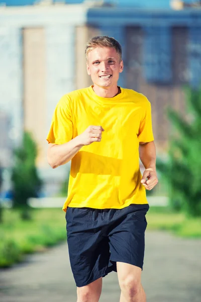 Sportieve man joggen in straat skyline van de stad. Buiten fitness. — Stockfoto
