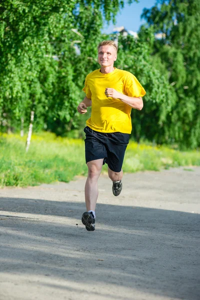 Sporty man jogging in city street park. Outdoor fitness. — Stock Photo, Image